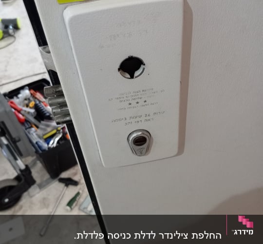 מנעול דלת עם חור מפתח וכלי עבודה ברקע